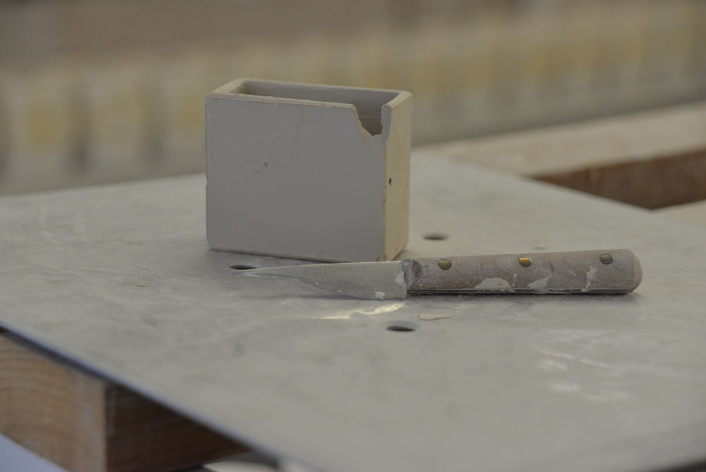 Retouching a raw CWC ceramic sleeve with a knife at GMUNDNER Keramik in Gmunden