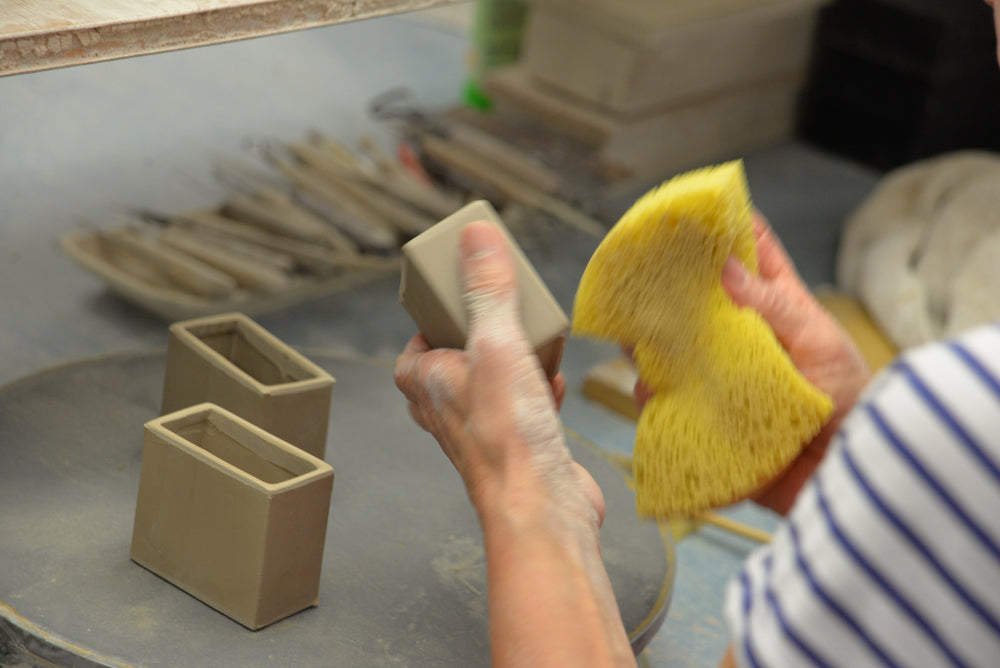 Sponging a raw CWC ceramic sleeve with a natural sponge at GMUNDNER Keramik in Gmunden