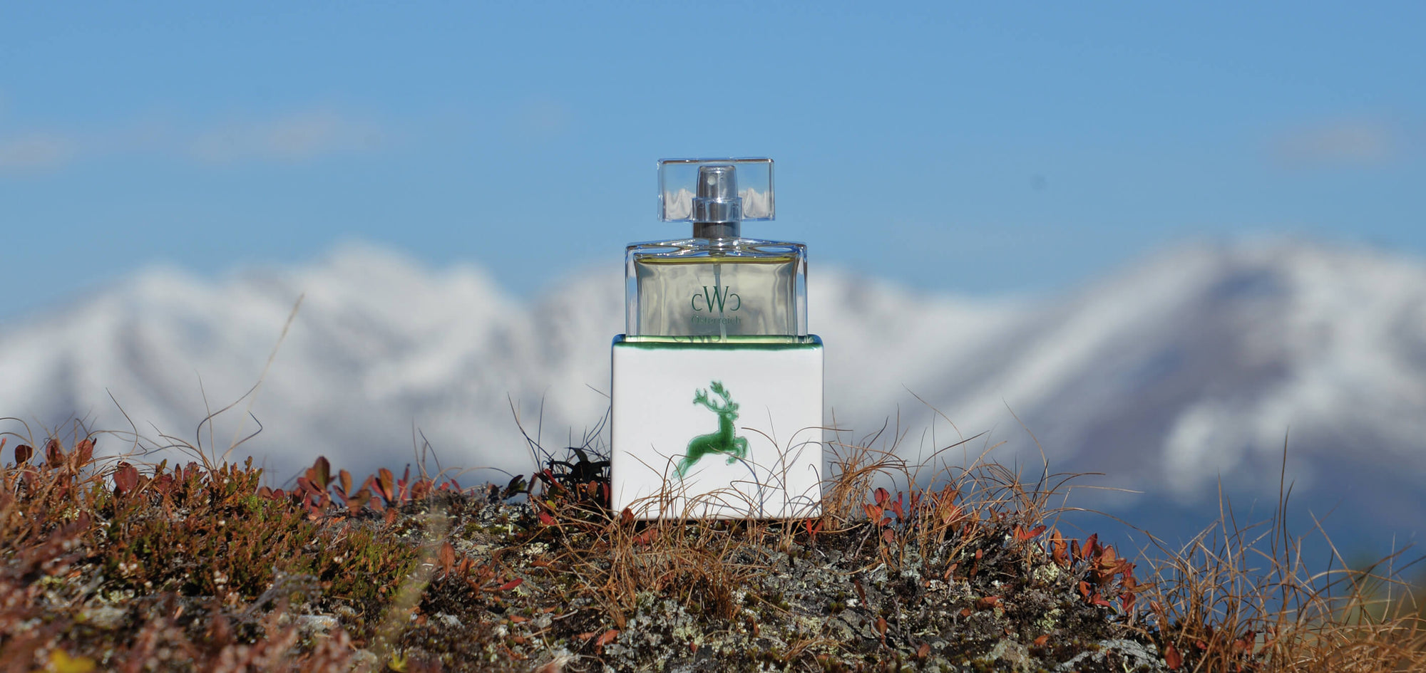 CWC Eau de Parfum GRÜNER HIRSCH vor alpiner Bergkulisse in den österreichischen Alpen | CWC Eau de Parfum GREEN STAG featuring an alpine mountain backdrop in the Austrian Alps.
